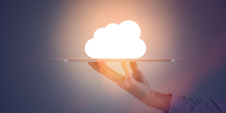 A hand holds up a tablet with a glowing cloud icon hovering over it.
